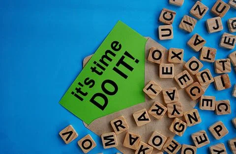 It's time, do it note in  gray envelope and a scattering of wooden letter blocks Foto stock