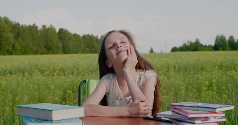 It's time to go back to school. A happy smiling school-age girl at a desk with Stock Footage 156555282