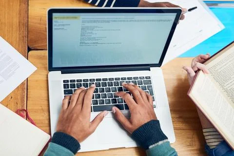 Its time to type out that assignment. a university student doing some research Stock Photos