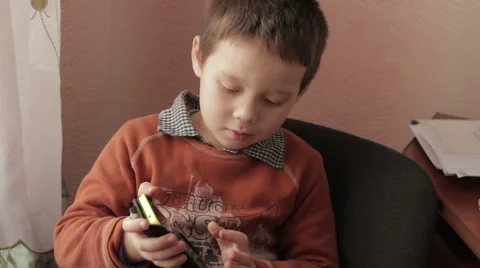 Ittle boy playing a game on your smartphone Stock Footage 59181005