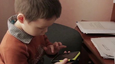 Ittle boy playing a game on your smartphone Stock Footage 59182376