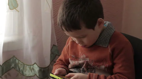 Ittle boy playing a game on your smartphone Stock Footage 59302458