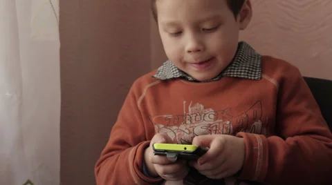 Ittle boy playing a game on your smartphone Stock Footage 59338179