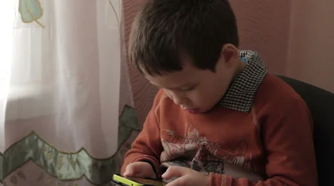 Ittle boy playing a game on your smartphone Stock Footage 59338496