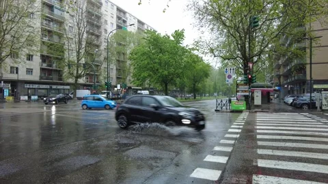 Ity intersection with cars driving through puddles in Italy. Stock Footage 332661968