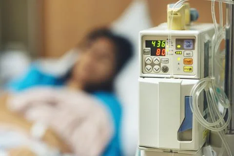 IV machine while and blurred of patient woman lying sleeping Foto stock