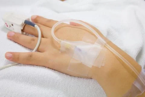 Iv solution in a patients hand Stock Photos