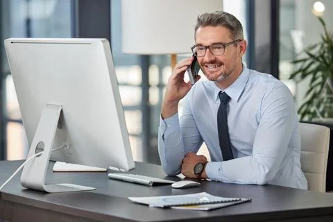Ive been expecting your call. a mature businessman sitting at his desk and Stock Photos