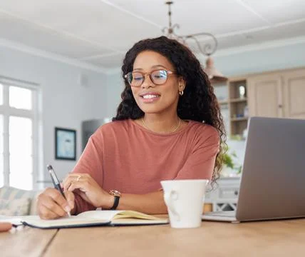 Ive been making great progress today. a young woman writing notes while working Stock Photos