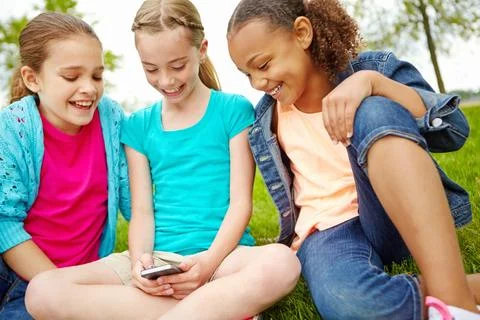 Ive got a text. Three little girls spending time together and sharing a Stock Photos