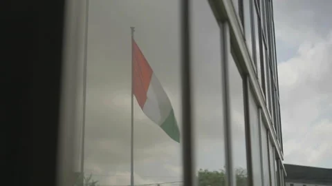 Ivorian flag waving in wind reflected in glass window Vídeos de archivo 333561546