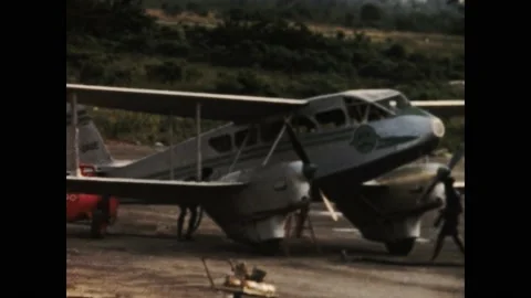 Ivory coast 1950s, Two men do maintenance on an old plane Stock Footage 233511246