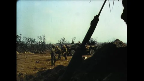 IWO JIMA - 1945: Artillery crew laying fire from a ridge emplacement Stock Footage 339215448
