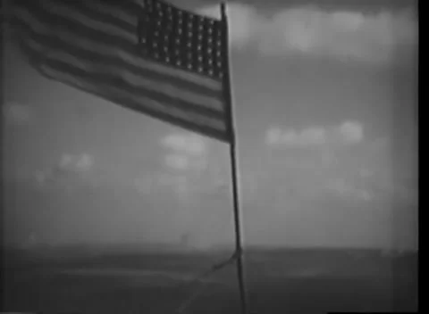 IWO JIMA - 1945: Beachhead — US flag flies above the Pacific sea 库存影片 342981323
