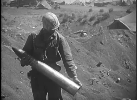IWO JIMA, JAPAN - 1945: Shell handling - Marine carries artillery projectile Stockbeeldmateriaal 344503050