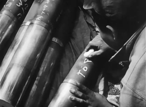 IWO JIMA, JAPAN - 1945: Shell inscription - A hand chalks an artillery shell Stockbeeldmateriaal 344505123