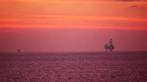 Jack up drilling rig in the middle of the ocean at sunrise time Video stock 74778510