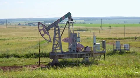 A jack-up drilling rig operates at a new oil field in the summer. A pumping unit Stock Footage 325033604