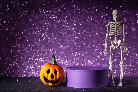 Jack-o-lantern and skeleton beside purple podium on glitter background for .. Fotos Stock