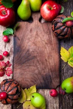 Jack-o-lantern around empty cutting board on wooden background. Autumn concep Stock Photos