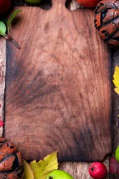 Jack-o-lantern around empty cutting board on wooden background. Autumn concep Stock Photos