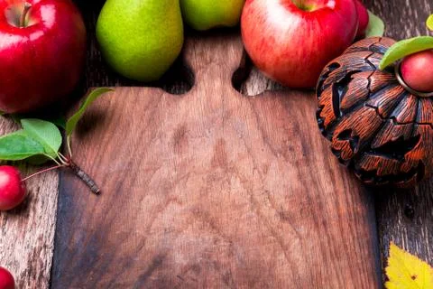 Jack-o-lantern around empty cutting board on wooden background. Autumn concep Stock Photos