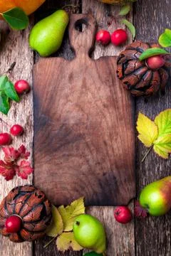 Jack-o-lantern around empty cutting board on wooden background. Autumn concep Stock Photos