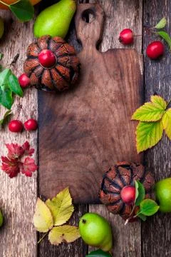 Jack-o-lantern around empty cutting board on wooden background. Autumn concep Stock Photos