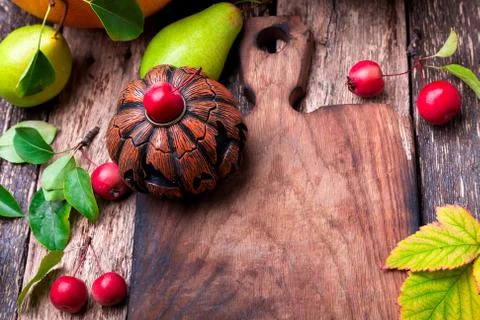 Jack-o-lantern around empty cutting board on wooden background. Autumn concep Stock Photos
