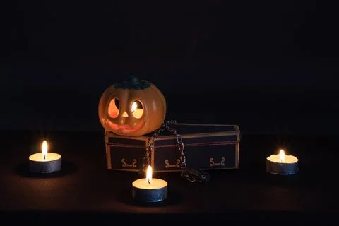 Jack o lantern on the chained-up vampire coffin in darkness. 스톡 사진