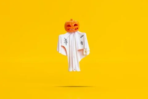Jack O Lantern Ghost Figurine Floating in the air on Bright Yellow Foto stock