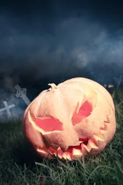 Jack-o-lantern in a graveyard at night Stock Photos