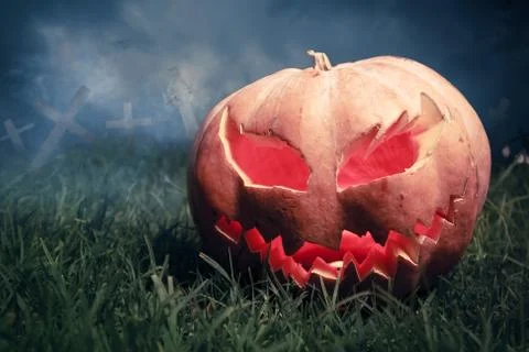 Jack-o-lantern in a graveyard at night Stock Photos