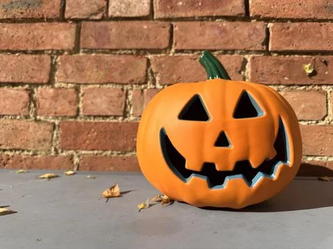 Jack-o-lantern halloween decaration pumpkin against brick wall Stock Photos