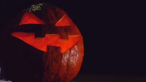 Jack O Lantern Halloween Pumpkin on a dark background. Halloween Stock Footage 149998549