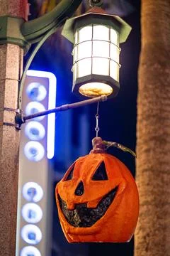 Jack-O’-Lantern Hanging Under Street Light with Neon Background Stock Photos