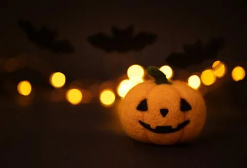 Jack o lantern head and bats on a dark background with bokeh.  Stock Photos