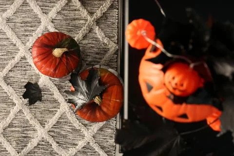 Jack-o'-lantern lights and black maple leaves on color surface, top view. S.. Stock Photos