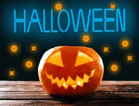 Jack-o-lantern pumpkin with burning candle and neon sign Halloween. Stock Photos