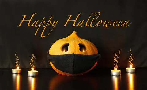 Jack-o-lantern pumpkin with face drawn on black protective mask Stock Photos