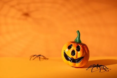 Jack-o-lantern with spiders and web shadow on orange background for Hallowe.. Stockfoto's