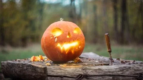 Jack o lantern on the table glows with magic light, a terrible pumpkin in the Foto stock