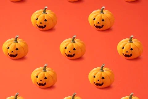 Jack-o-lanterns lined up regularly on an orange background 写真素材