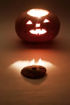 Jack o'lantern with the cut off top. Surrounded by mysterious darkness lights Stock Photos