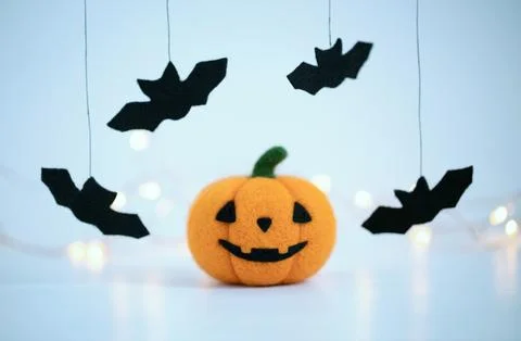 Jack pumpkin head and bats on blue background. Wool felted toy Halloween Stock Photos