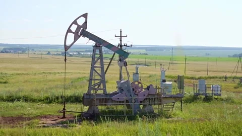 A jack-up rig operates at a green oil field in summer. Oil production in Russia Video stock 322104577