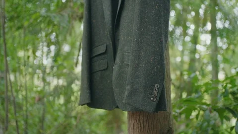 Jacket hanging on tree trunk in forest 스톡 동영상 331047752