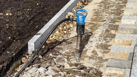 Jackhammer in broken footpath Stock Photos