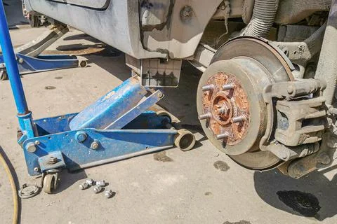 Jacking up a car to change a tire. Replacing car wheel using hydraulic jack Stock Photos