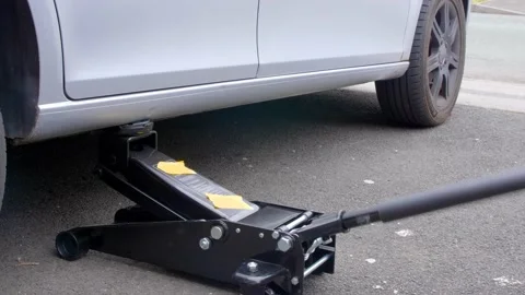 Jacking up a car for repairs Stock Footage 157060955